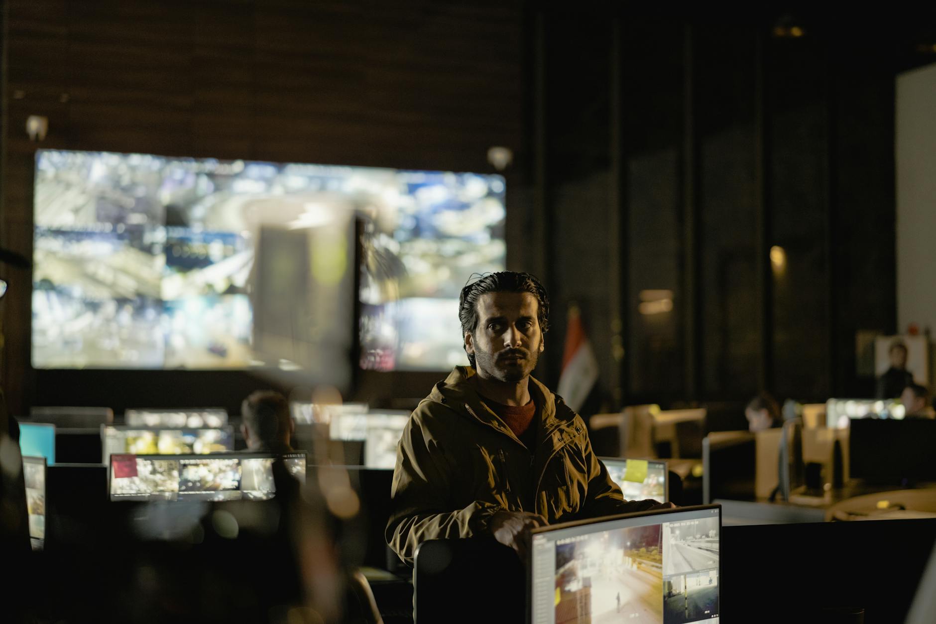 Zespół w nowoczesnym centrum monitoringu IT obserwuje wiele ekranów