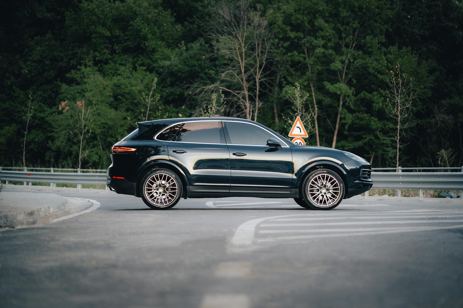 Czarny SUV BMW X5 E70 zaparkowany przy leśnej drodze