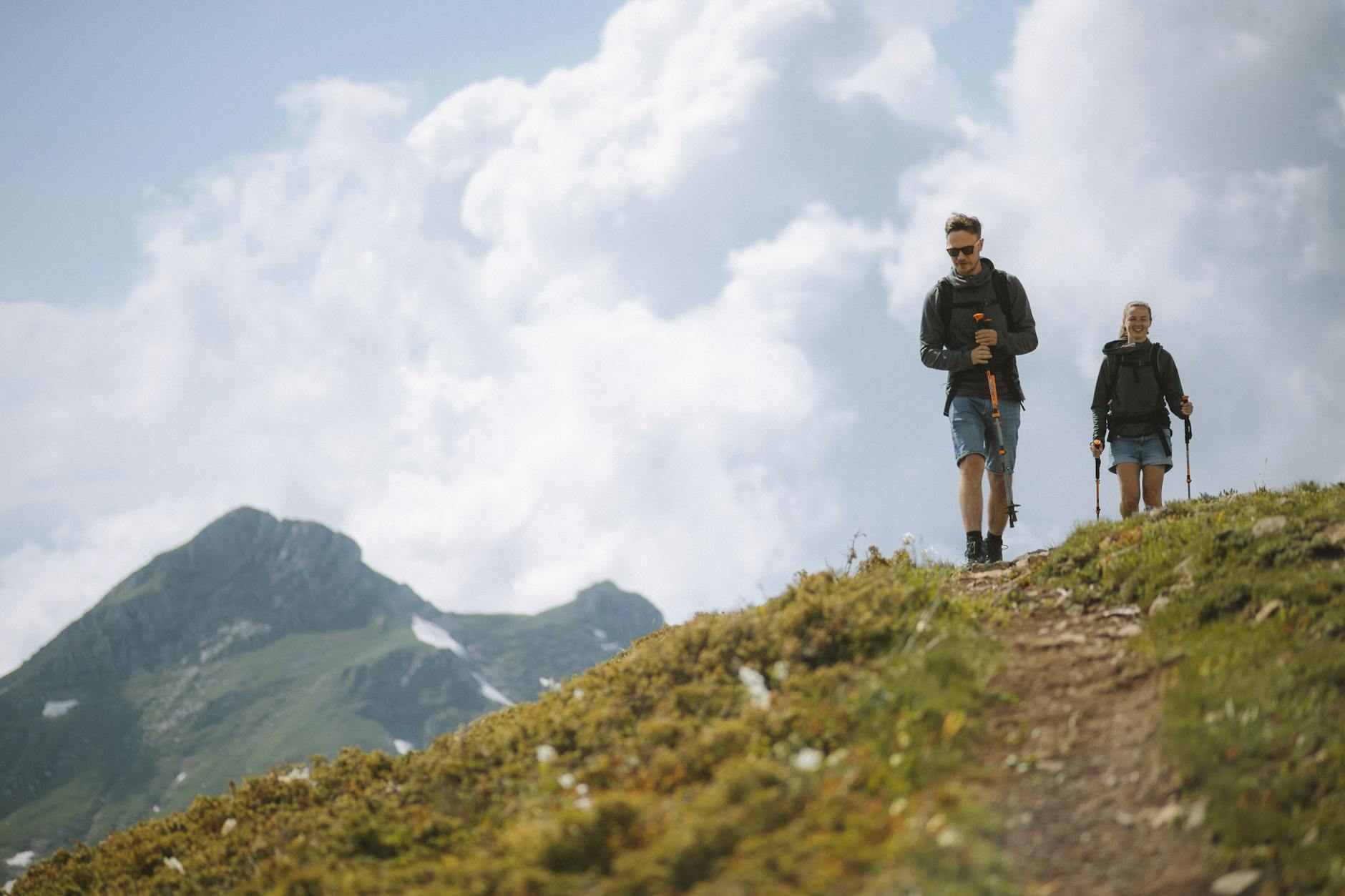 Para na górskim szlaku z kijkami trekkingowymi w pochmurny dzień