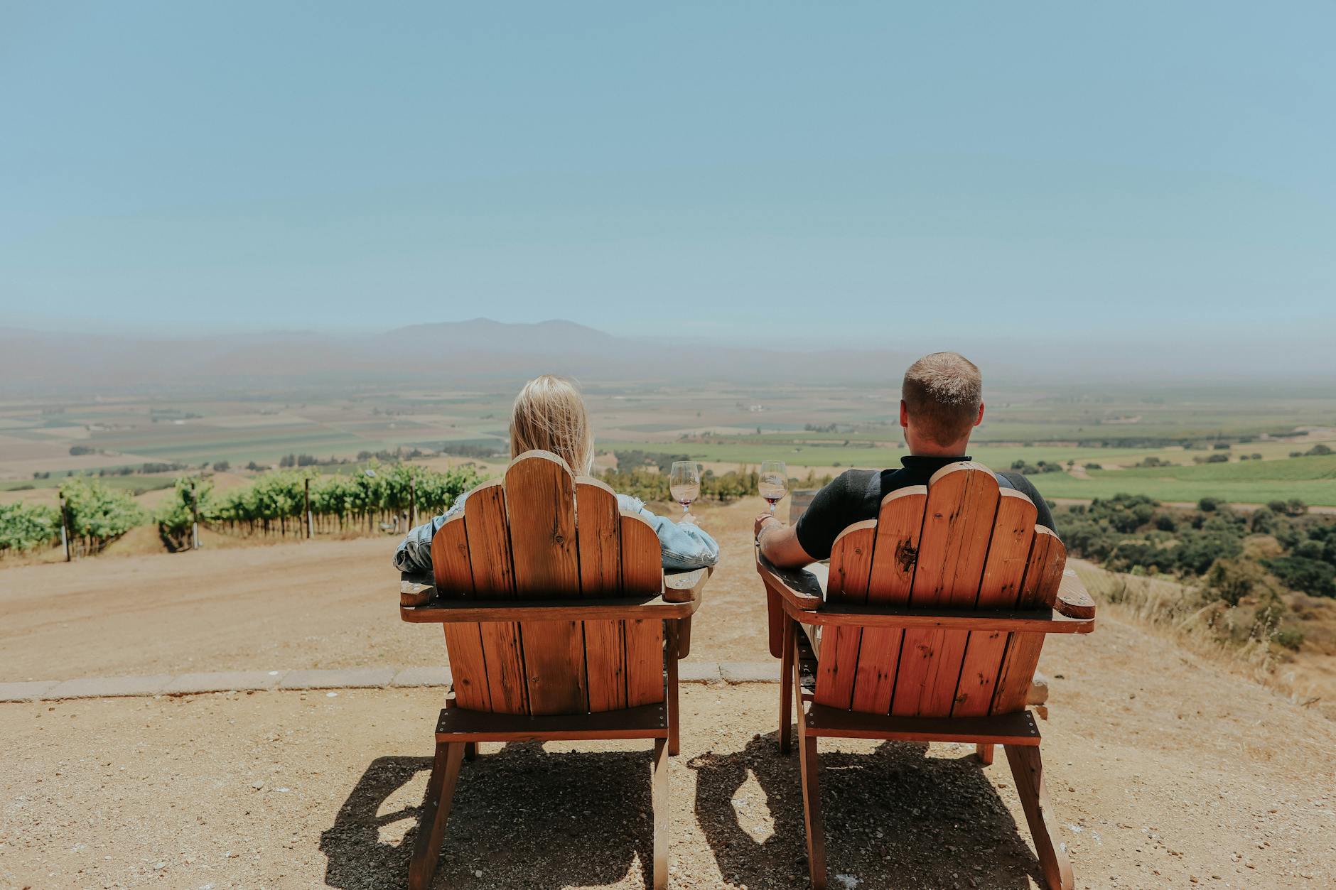 Para w drewnianych krzesłach patrzy na winnicę na Węgrzech