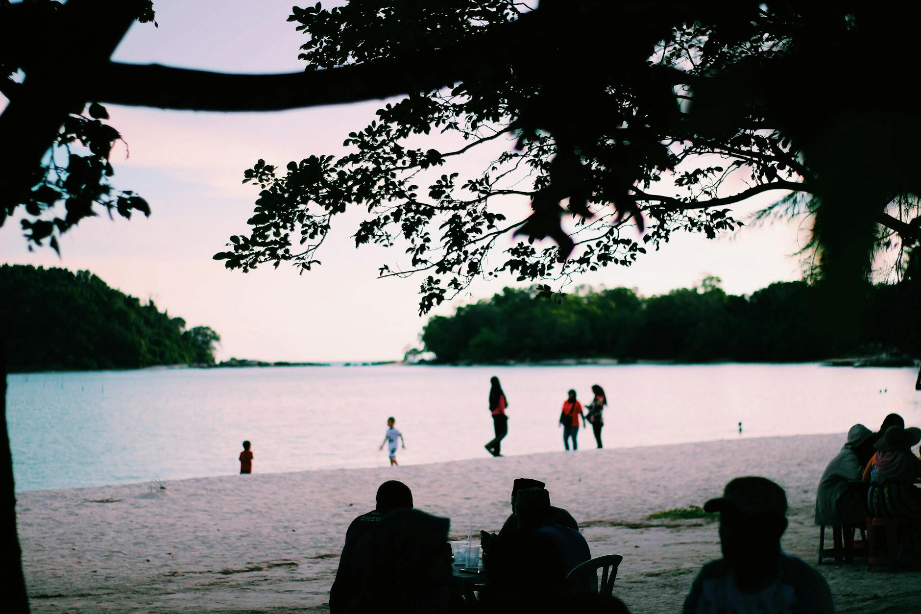 Plaża w Kedah o zachodzie słońca z ludźmi spacerującymi po brzegu