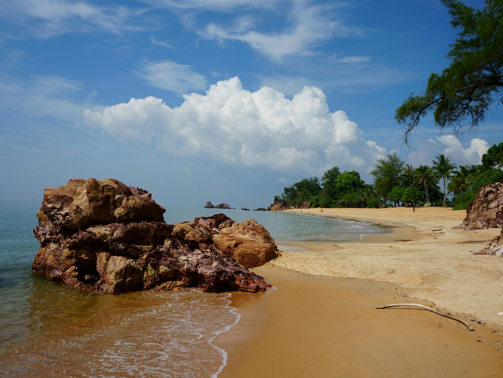 Tropikalna plaża w Malezji z palmami, skałami i błękitem nieba