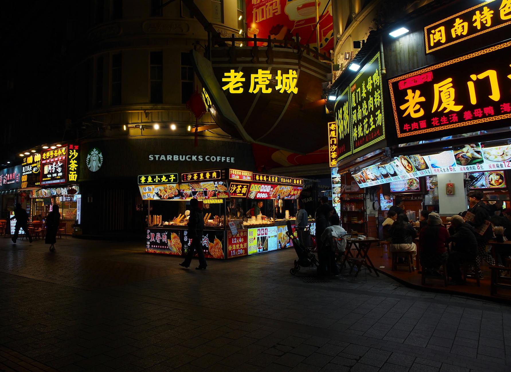 Nocny targ ulicznego jedzenia w Xiamen z neonami i lokalnymi barami
