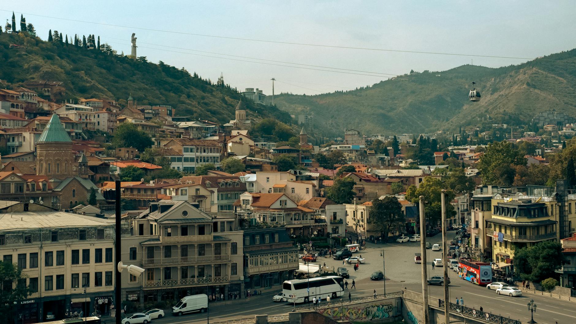 Panorama Tbilisi z historyczną zabudową i wagonikiem kolejki linowej