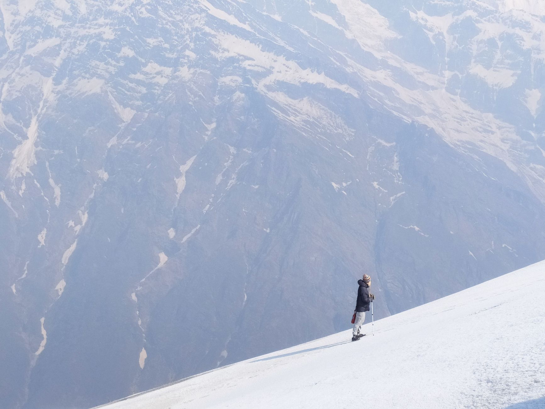 Trekker na ośnieżonym stoku w Nepalu z himalajskimi szczytami w tle